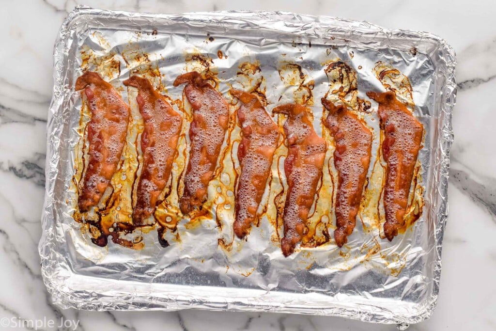 overhead of baking sheet covered in foil with strips of cooked bacon