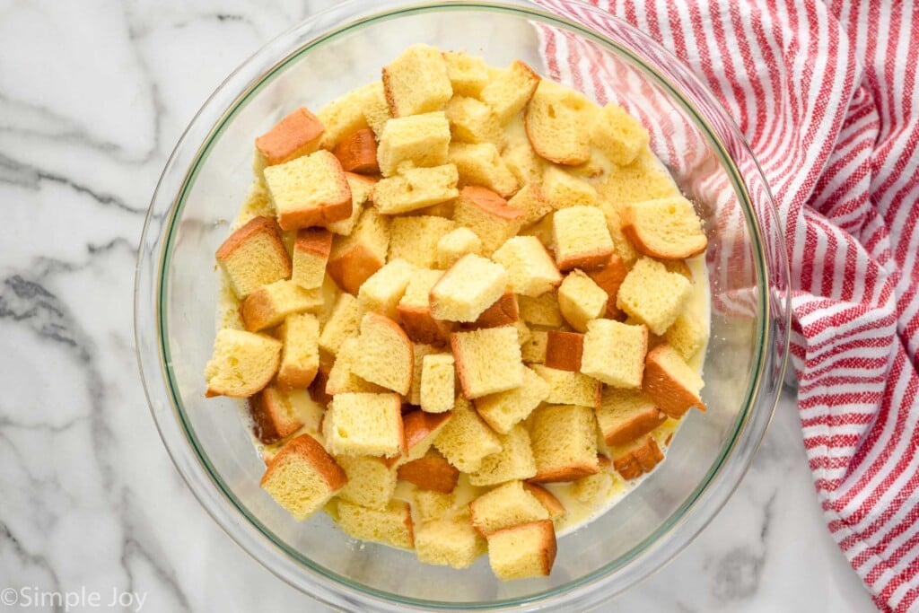 Overhead view of bread cubes in mixing bowl of ingredients for Bread Pudding recipe