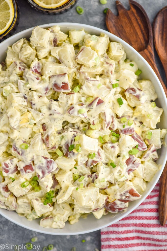 overhead of bowl of Potato Salad with spoons sitting beside for serving