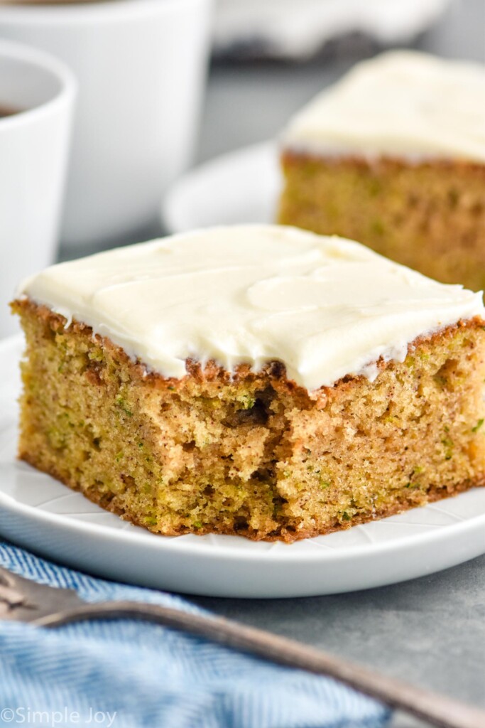 Slice of Zucchini Cake served on a plate with a fork beside