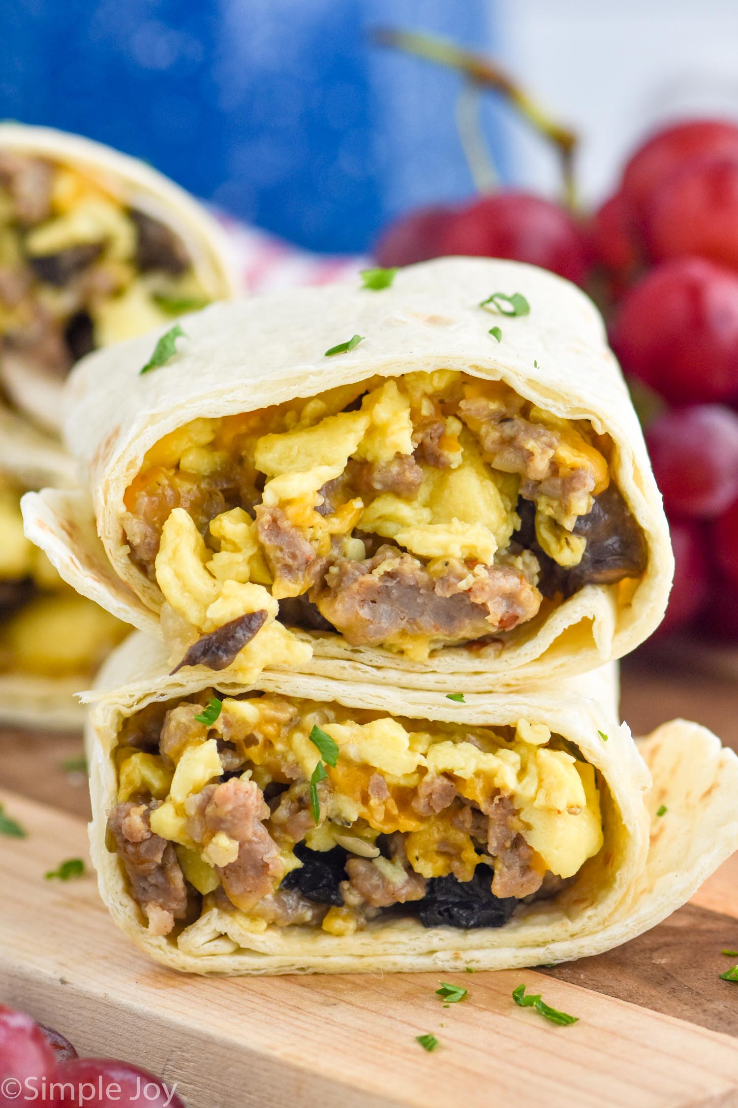 Breakfast Burrito cut in half with filling of eggs, cheese, sausage, and mushrooms