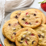Pinterest graphic for Strawberry Cookies. Text says "delicious Strawberry Cookies simplejoy.com" Image shows a plate of Strawberry Cookies with fresh strawberries and chocolate chips sitting beside.