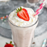 Pinterest graphic for homemade milkshakes. Text says "the best strawberry milkshake simplejoy.com" Image shows a glass of strawberry milkshake topped with whipped cream and a fresh strawberry