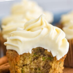 Pinterest graphic for Zucchini Cupcakes. Text says "the best Zucchini Cupcakes simplejoy.com" Image shows Zucchini Cupcake with bite taken out topped with cream cheese frosting.
