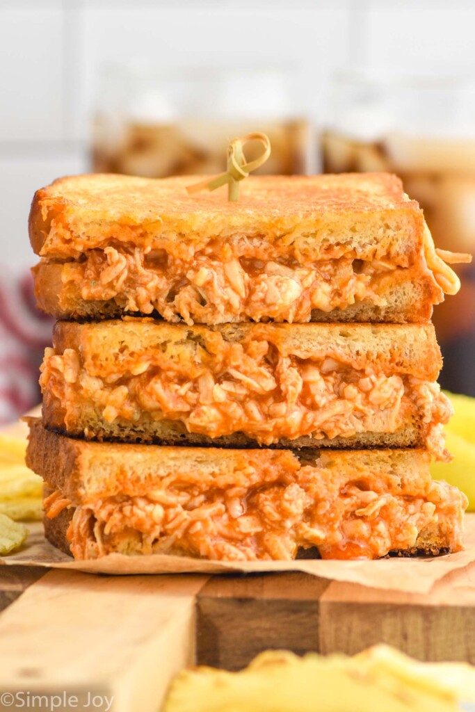 stack of Buffalo Chicken Sandwich halves with potato chips surrounding