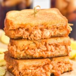 Stack of Buffalo Chicken Sandwich halves with potato chips sitting in background