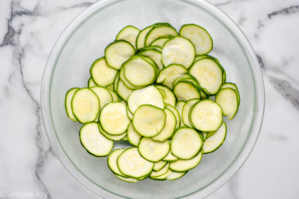 overhead of bowl of slices of zucchini to make Italian Zucchini Fritters