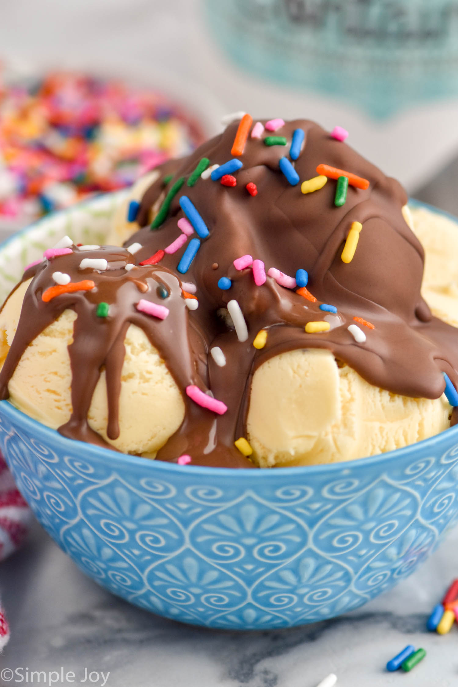 bowl of vanilla ice cream topped with magic shell and sprinkles