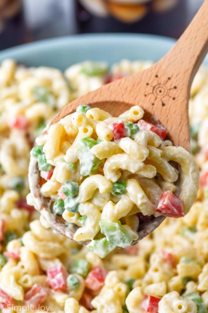 spoon holding Macaroni Salad out of bowl of Macaroni Salad