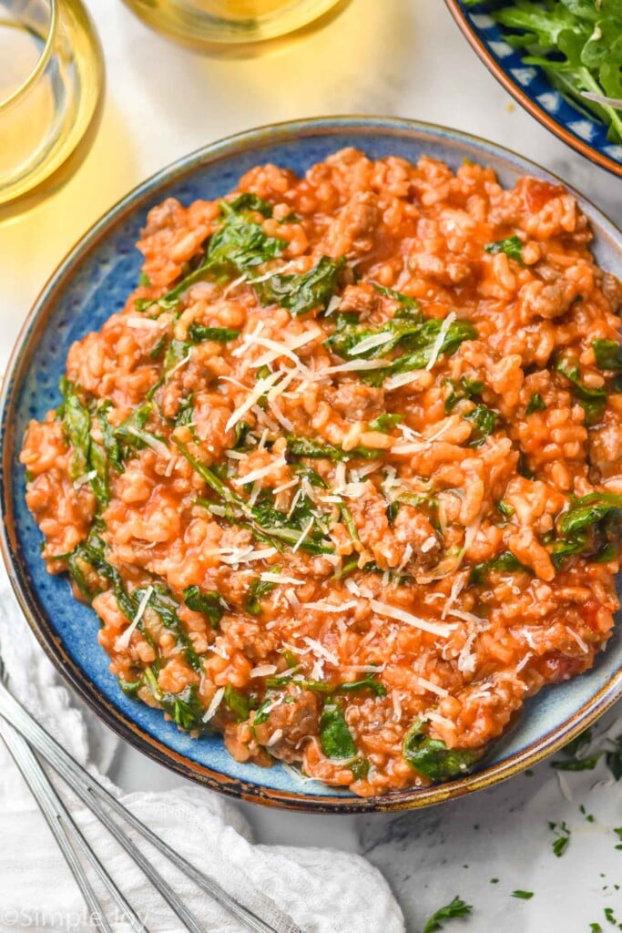 overhead of plate of risotto with spinach and shredded parmesan cheese