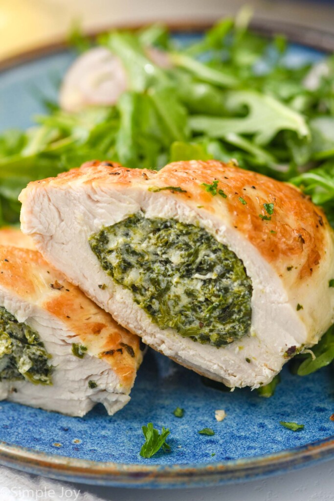 close up of inside of Stuffed Chicken Breast on a plate with salad