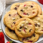 plate of Strawberry Cookies with fresh strawberries and chocolate chips sitting beside.