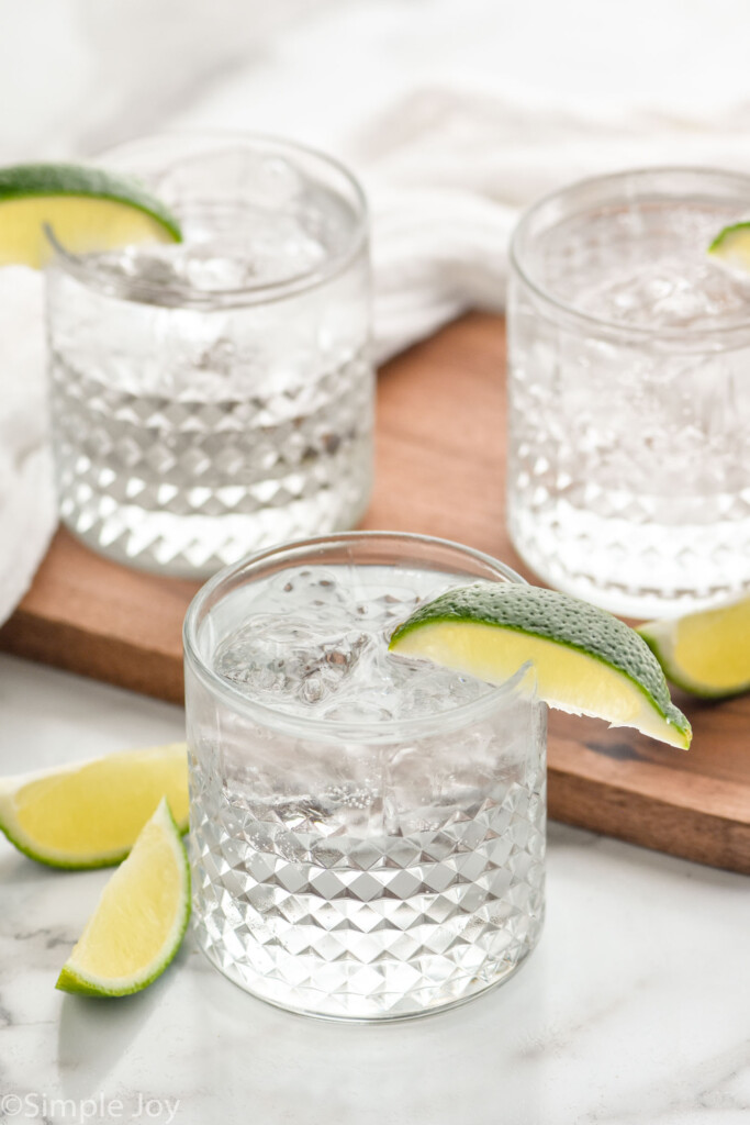 Three glasses of vodka press with ice and lime wedges