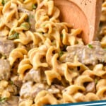 Pinterest graphic for Beef Stroganoff. Image shows close up of wooden spoon in Beef Stroganoff. Text says "beef stroganoff simplejoy.com"