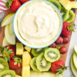 Pinterest graphic for Fruit Dip. Image shows overhead of bowl of fruit dip on a serving board with fresh strawberries, apple slices, kiwi, grapes, and pineapple. Text says "two ingredient fruit dip recipe simplejoy.com"