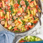 Pinterest graphic for One Pot Sausage Pasta. Image shows overhead of skillet of One Pot Sausage Pasta with bowl of salad, glasses of white wine, and pieces of bread surrounding. Text says " One Pot Sausage Pasta simplejoy.com"