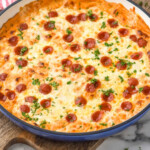 Pinterest graphic for Pizza Dip. Image shows a skillet of pizza dip topped with pepperoni and fresh parsley. Text says "super easy Pizza Dip recipe simplejoy.com"