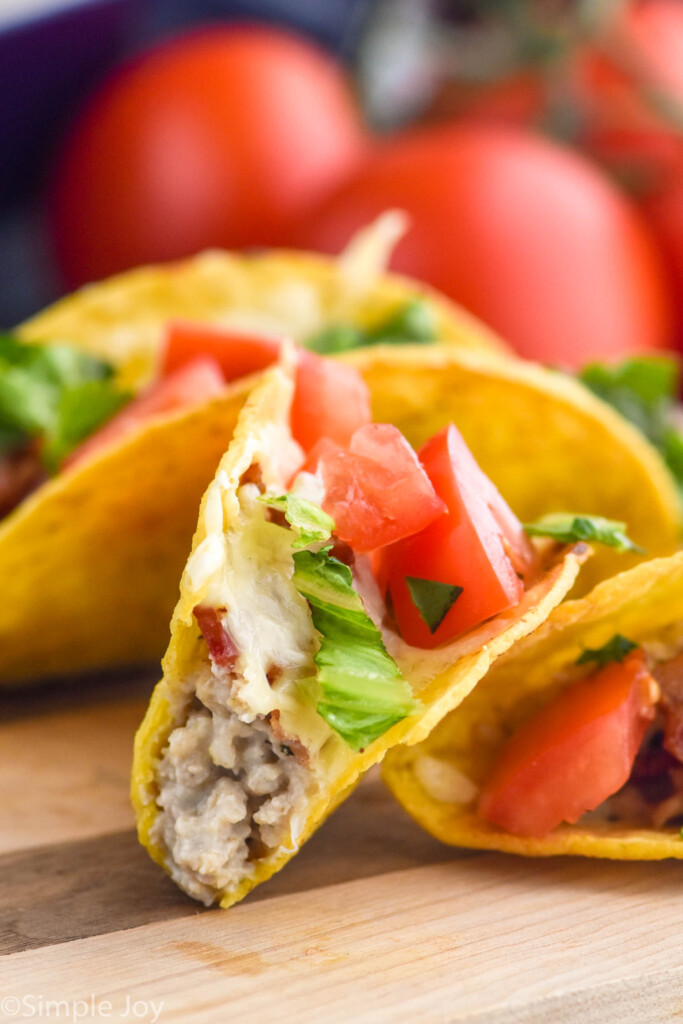 close up of BLT Baked Tacos with tomatoes sitting in background