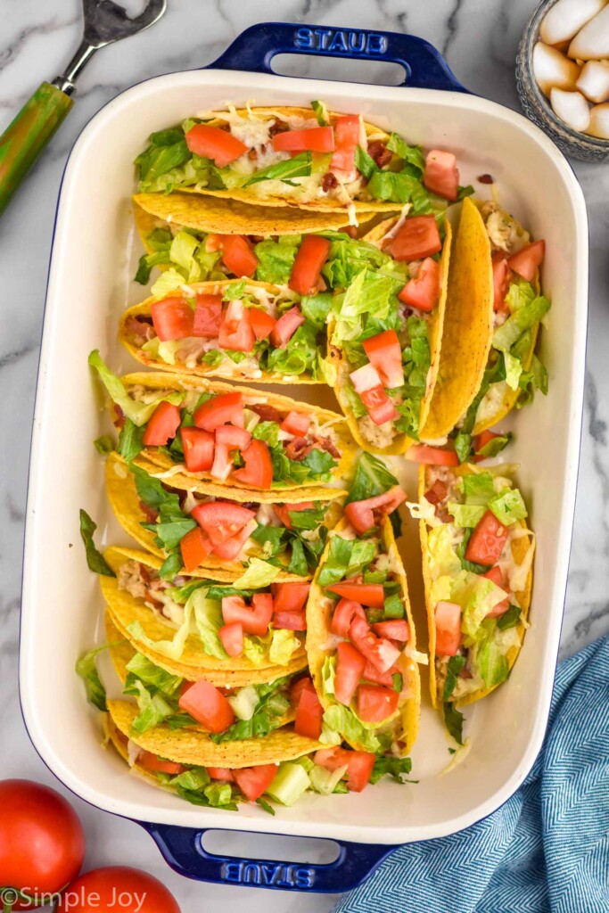 overhead of baking dish of BLT Baked Tacos topped with diced tomatoes and lettuce