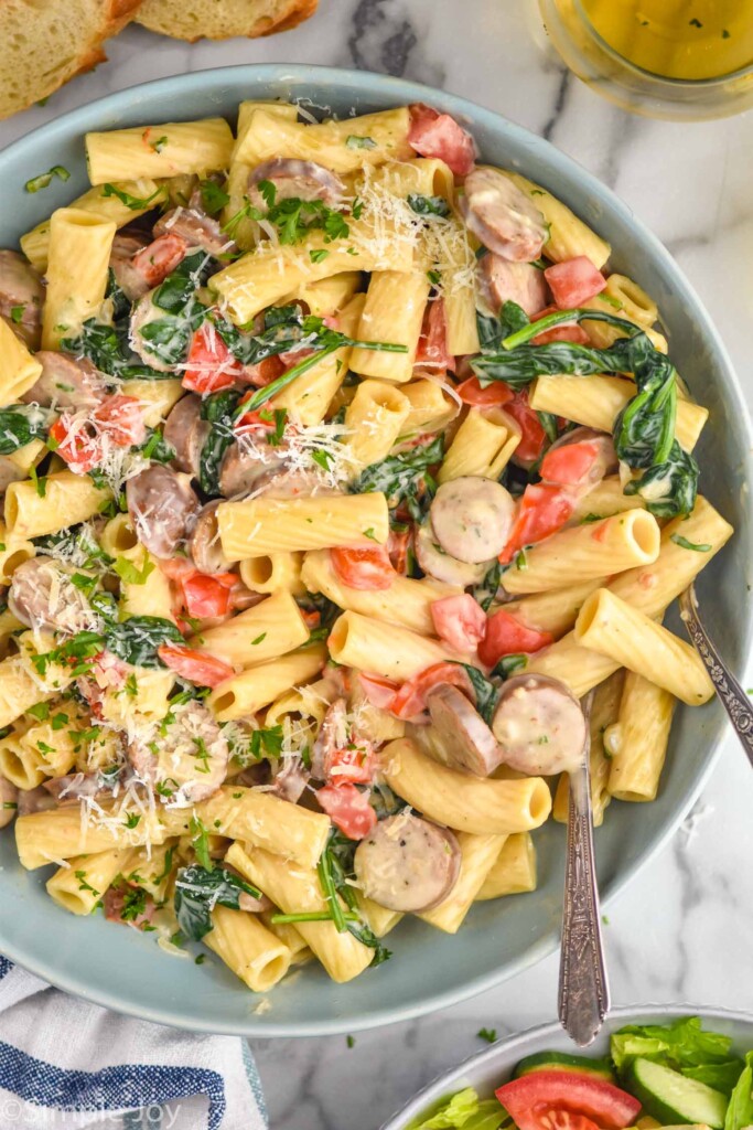 overhead of bowl of One Pot Sausage Pasta with two spoons for serving