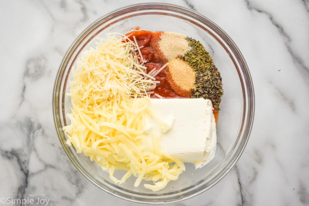 overhead of large glass bowl of Pizza Dip ingredients