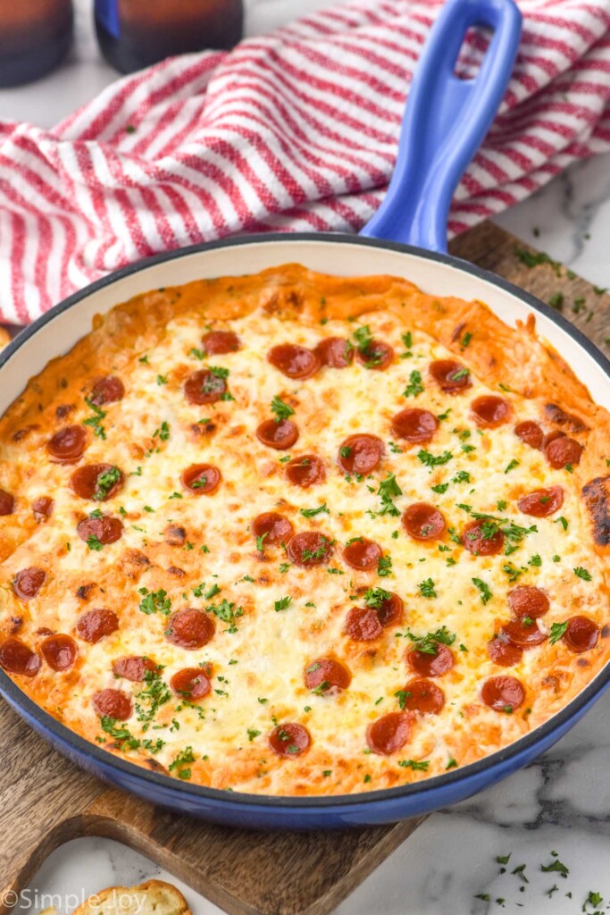 Large skillet of Pizza Dip topped with pepperoni and fresh parsley