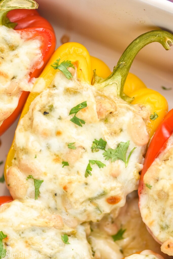 close up of White Chicken Chili Stuffed Peppers in a baking dish topped with fresh parsley