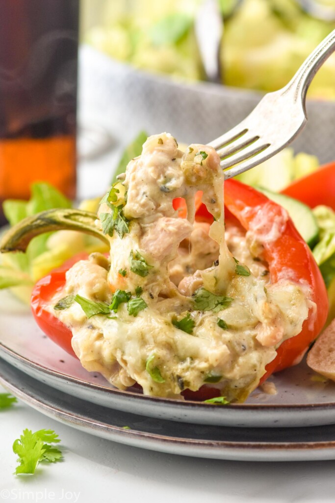 fork pulling bite of White Chicken Chili Stuffed Pepper out of the pepper, topped with parsley