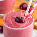 pinterest graphic of angled view of a cherry smoothie in a glass with a cherry on top and two paper straws, says: "the best cherry smoothie simplejoy.com"