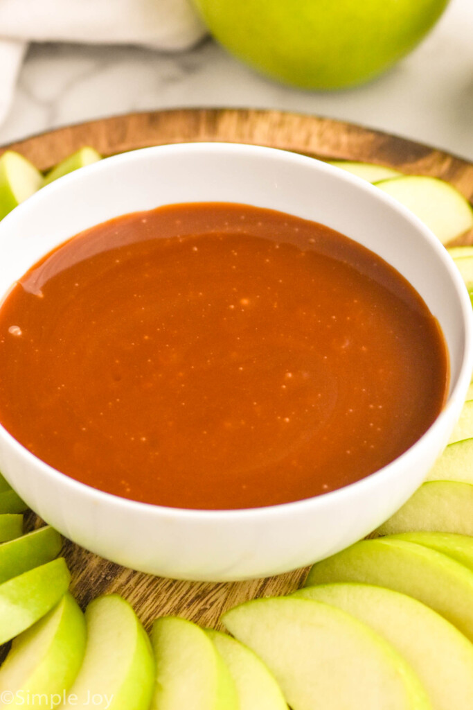 Bowl of caramel apple dip. Apple slices surrounding bowl