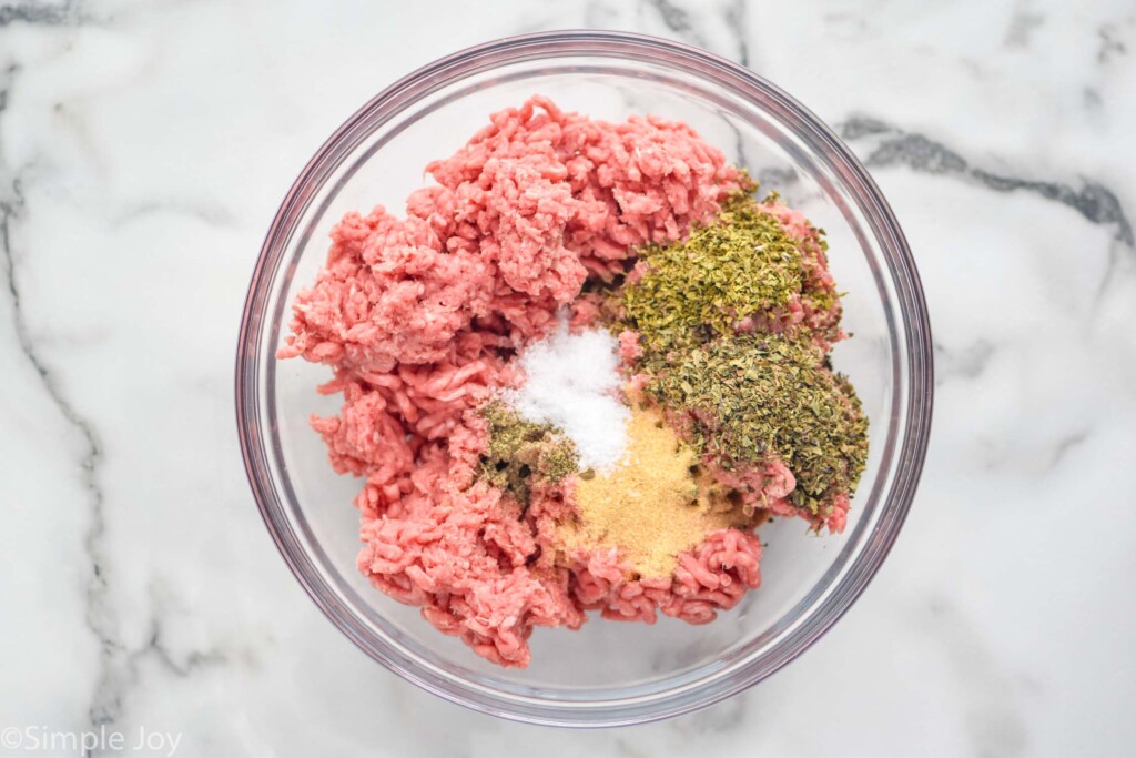 overhead of ground beef and seasonings to make pizza burgers