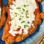 Pinterest graphic for Chicken Parmesan. Image shows a piece of Chicken Parmesan topped with melted cheese and fresh parmesan on a plate. Says "fool proof Chicken Parmesan simplejoy.com"