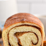 Pinterest graphic for cinnamon bread. Text says "the best cinnamon bread simplejoy.com" Image shows close up of the inside of a loaf of cinnamon bread on a wooden board for serving