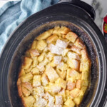 Pinterest graphic for Crockpot French Toast. Says "slow cooker french toast simplejoy.com" Image shows overhead of crockpot of Crockpot French Toast dusted with powdered sugar