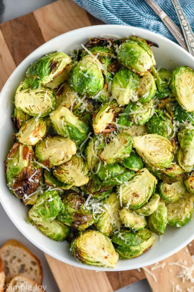 overhead of bowl of Air Fryer Brussels Sprouts topped with parmesan cheese