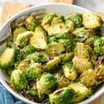 bowl of Air Fryer Brussels Sprouts topped with parmesan cheese with a fork