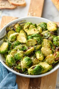 bowl of Air Fryer Brussels Sprouts topped with parmesan cheese with a fork