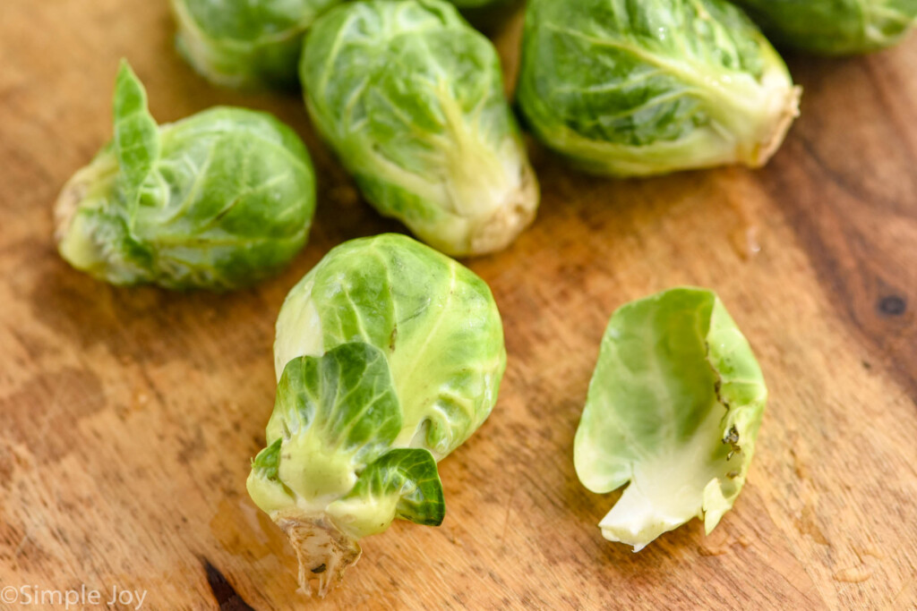 close up of raw brussel sprouts on a wooden cutting board