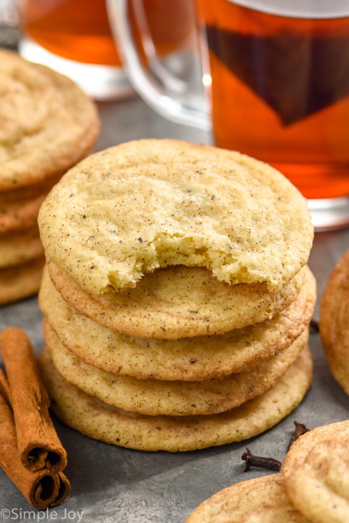 Stack of Chai Sugar Cookies with cookies and cinnamon sticks sitting beside