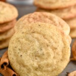 Chai Sugar Cookie with stacks of Chai Sugar Cookies and cinnamon sticks siting behind