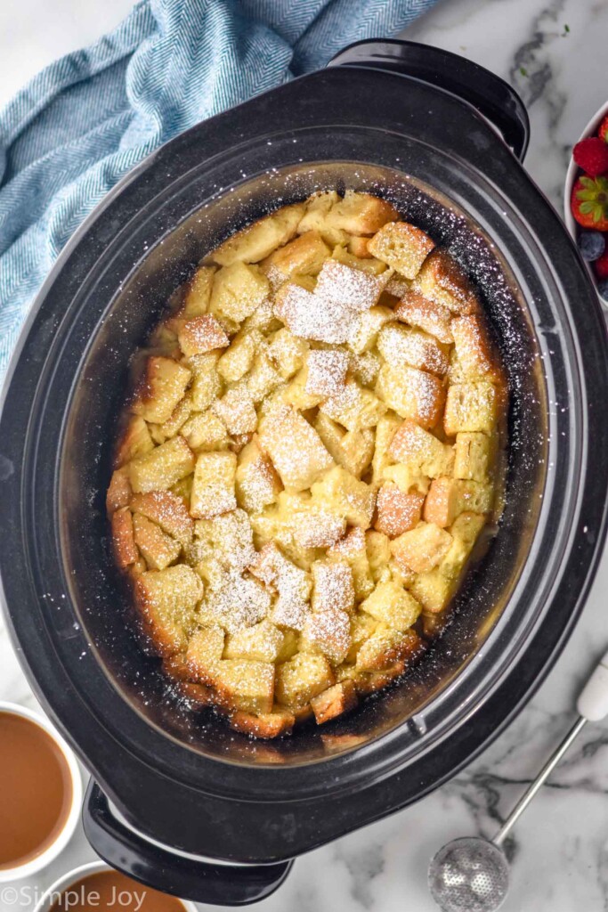 overhead of crockpot of crockpot french toast topped with powdered sugar