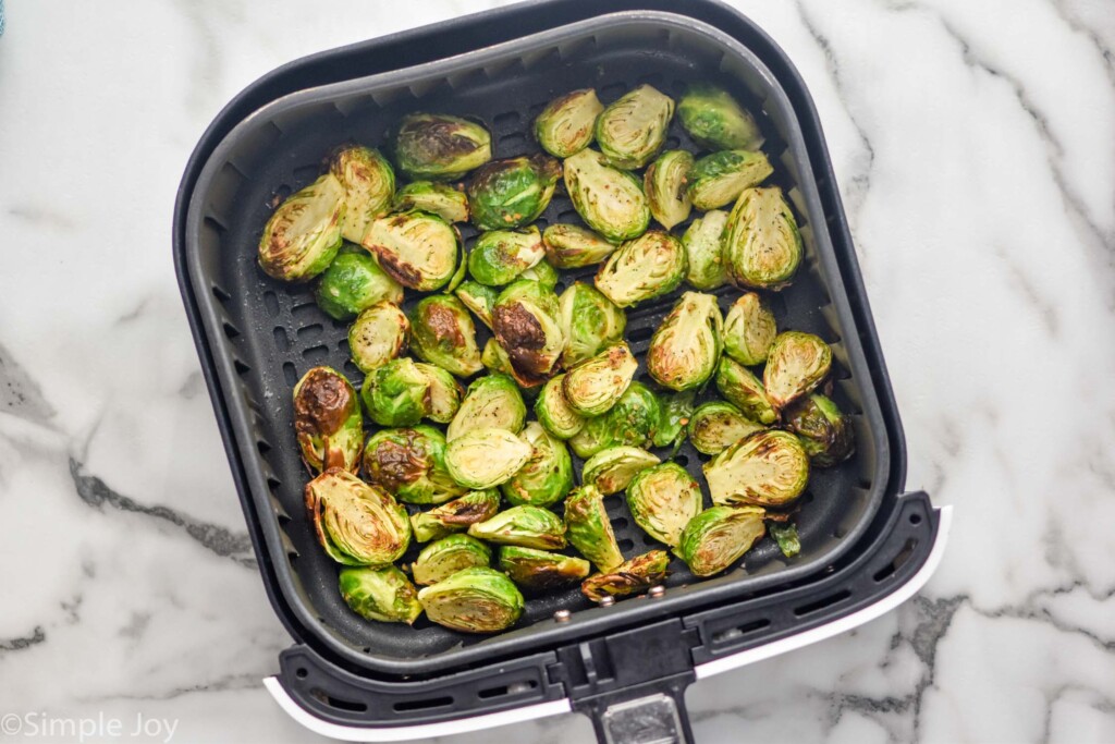 overhead of air fryer basket of cooked Air Fryer Brussels Sprouts