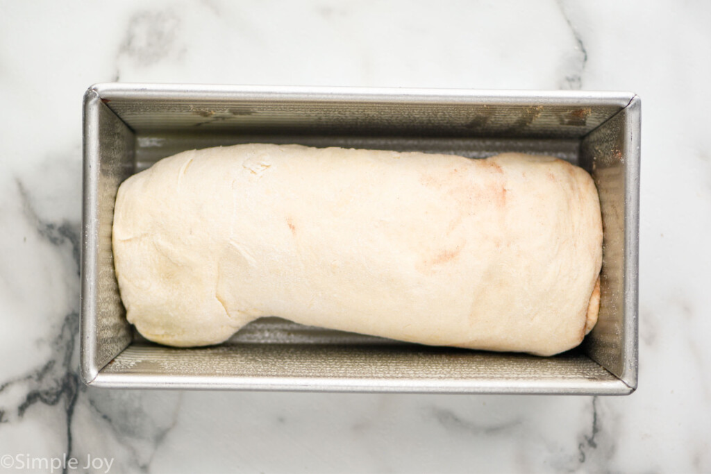 overhead of bread pan with rolled up Cinnamon Bread dough