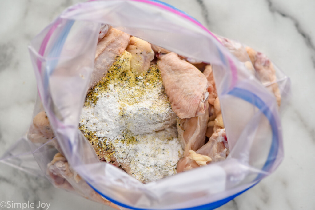 overhead of plastic ziplock bag of Lemon Pepper Wings ingredients, including chicken wings and seasonings