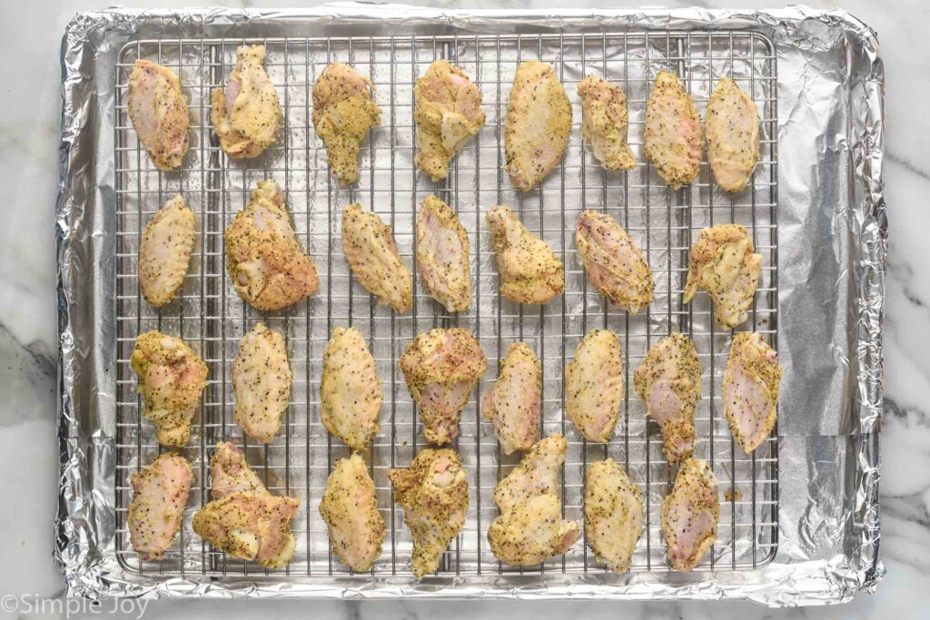 overhead of wire rack on a foil lined baking sheet with Lemon Pepper Wings on top