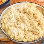 bowl of Instant Pot Risotto topped with black pepper and shredded parmesan cheese.