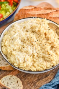 bowl of Instant Pot Risotto topped with black pepper and shredded parmesan cheese.