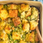 Pinterest graphic for Cornbread Stuffing. Text says "the best Cornbread Stuffing simplejoy.com" Image shows close up of baking dish of Cornbread Stuffing with a wooden spoon for serving