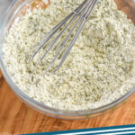 Pinterest graphic for Homemade Ranch Seasoning. Image shows a glass bowl of Homemade Ranch Seasoning with wire whisk. Says "ranch seasoning simplejoy.com"