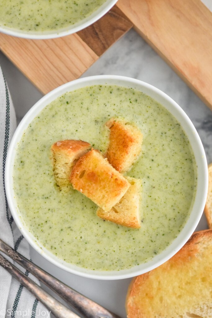 overhead of bowl of homemade Cream of Broccoli Soup topped with croutons